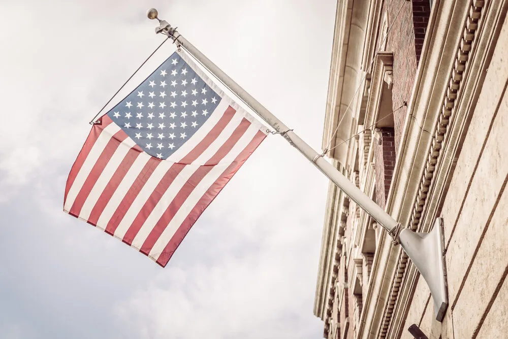 American flag waving outside a Texas building, symbolizing MUD financing solutions and water district funding programs wit...