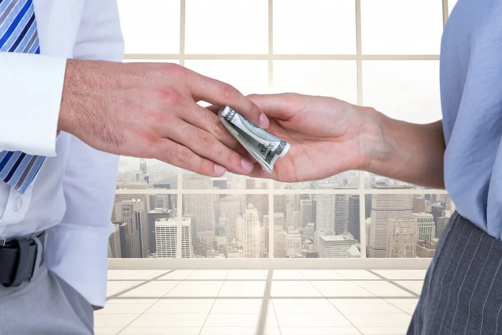 Businessman and woman exchanging money, symbolizing Texas MUD financing and MUD reimbursement financing options for water ...