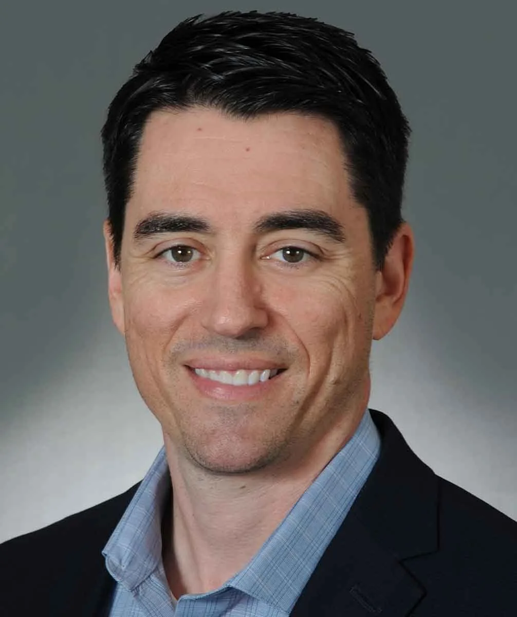 Man in business attire smiling, representing expertise in Texas MUD financing options and MUD district funding solutions.