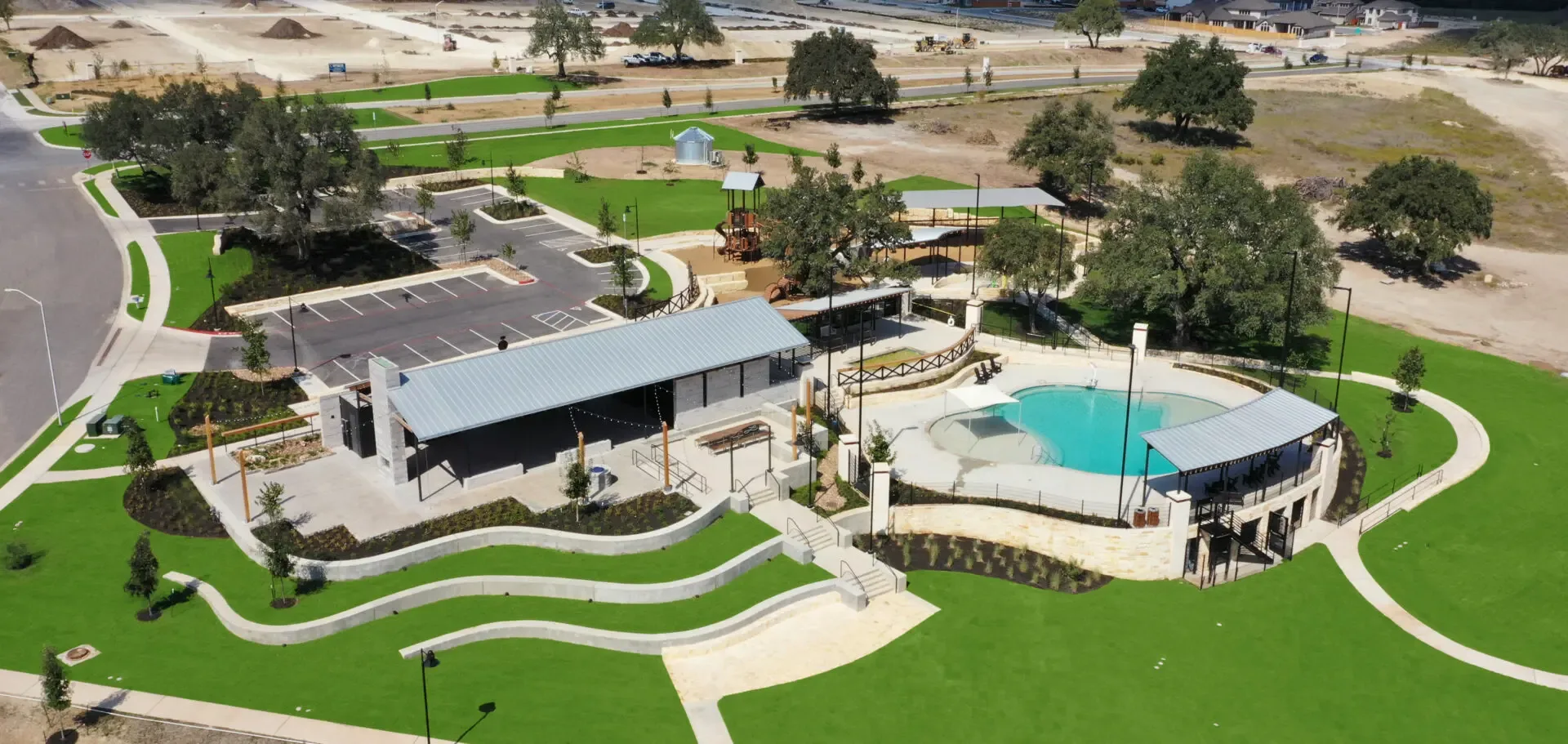 Aerial view of a modern Texas MUD community with pool, park, and clubhouse, showcasing MUD district funding solutions and ...