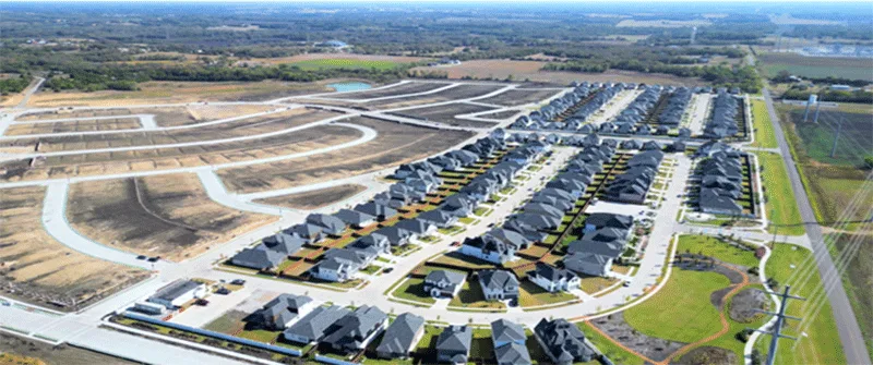 Aerial view of a new suburban neighborhood in Texas with many houses and undeveloped land, illustrating the need for Texas...